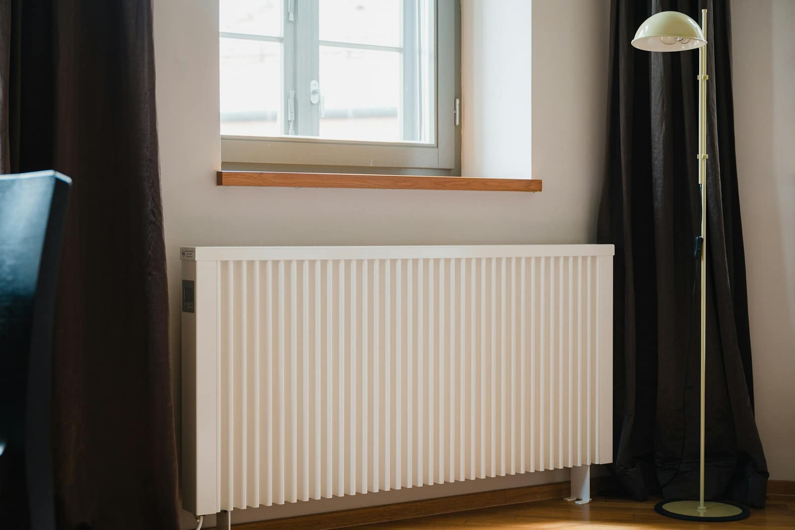 Yaşayış otağının divarında quraşdırılmış ağ rəngli müasir isitmə radiatoru